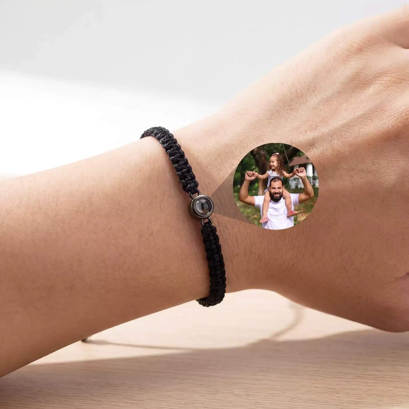 Bracelet cordon noir porté, avec la photo projetée à côté